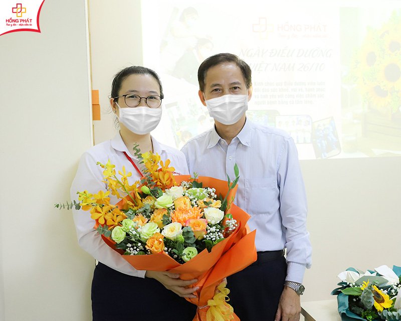 TS.BS Phạm Thị Ngọc Bích và ông Nguyễn Đức Văn đã thay mặt ban lãnh đạo Bệnh viện gửi tặng những bó hoa tươi thắm